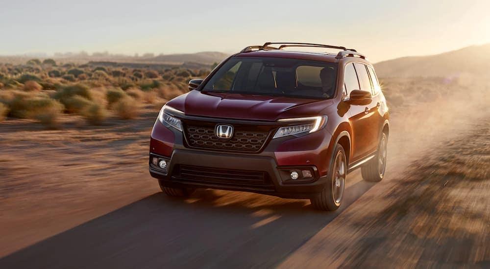 A red 2020 Honda Passport is shown from the front at an angle.
