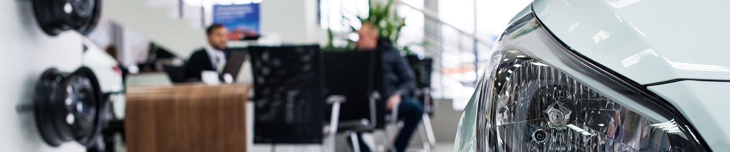 blurred image of the side of a car in a dealership